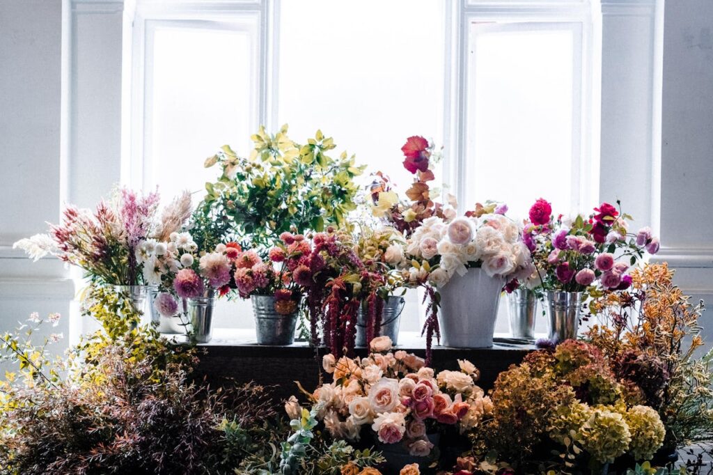 Beautiful array of colorful flowers in vases with natural indoor lighting.